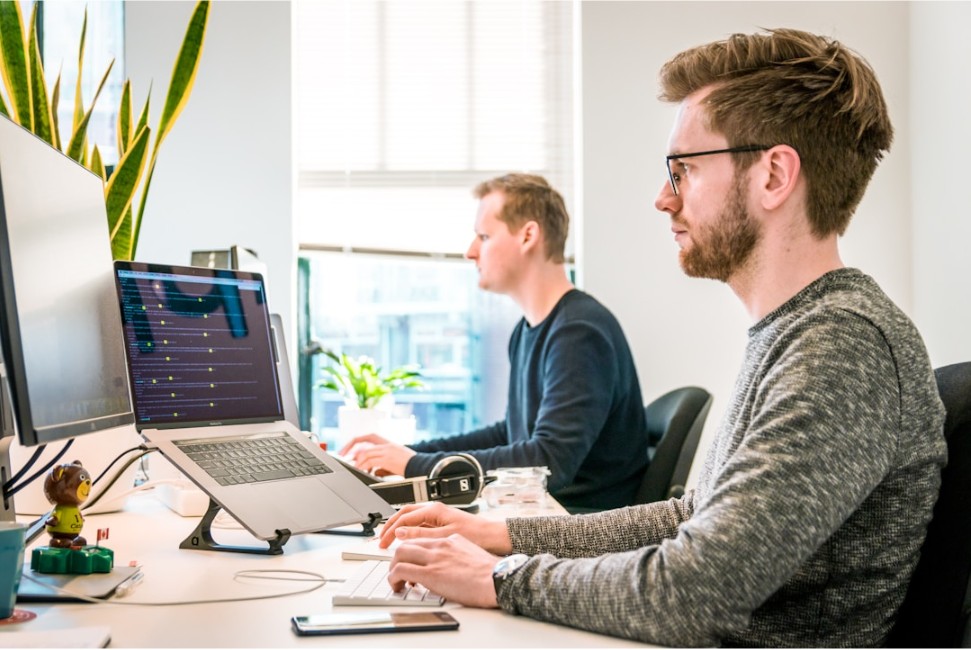 Team members in an office setting using their computers to understand AI integration systems in business operations